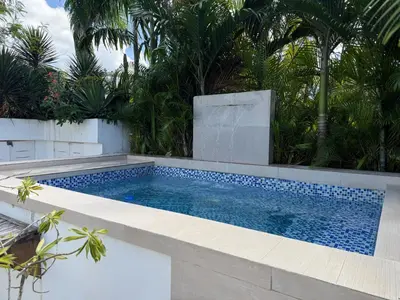 a swimming pool in the middle of a yard with trees at Tropical Penthouse in the Heart of Las Terrenas! in Las Terrenas