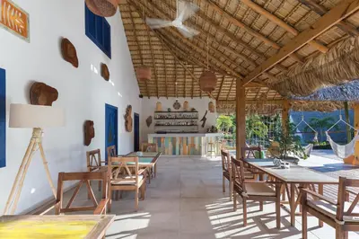 a dining room with tables and chairs and a ceiling at Punta Rucia Lodge Hotel Boutique & Spa in Punta Rucia