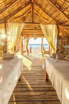 two beds in a room with a view of the beach at Punta Rucia Lodge Hotel Boutique & Spa in Punta Rucia