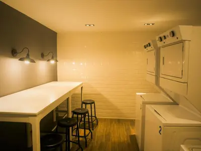 a kitchen with a counter with stools and a refrigerator at Estancia Casa Real Frente a la Zona Colonial in Calero