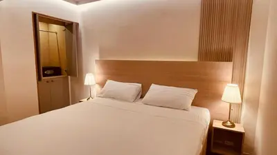 a bedroom with a large white bed and a mirror at Hotel La Colonia in Santo Domingo