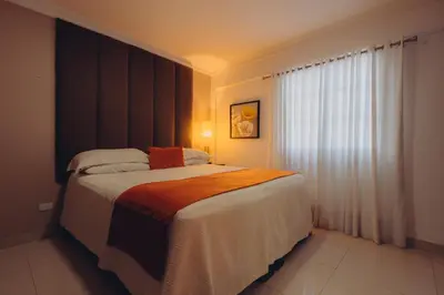 a bedroom with a large bed and a window at Hotel La Colonia in Santo Domingo