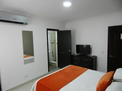 a bedroom with a bed and a television in it at Hotel La Colonia in Santo Domingo