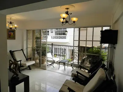a living room with a view of a balcony at Hotel La Colonia in Santo Domingo