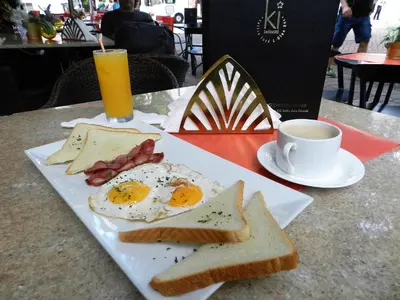 a plate with eggs and toast and a cup of coffee at Hotel La Colonia in Santo Domingo