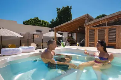 a man and a woman sitting in a swimming pool at Hotel Boutique Casa Sánchez in Santo Domingo