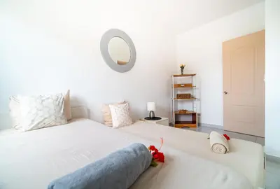 a bedroom with a white bed and a mirror at Villa Pauline in Bayahibe
