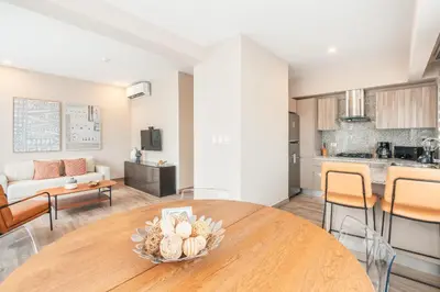 a kitchen and a living room with a wooden table at Fully Serviced Apartment at Regatta Living II - 302 in Santo Domingo