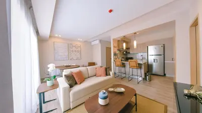 a living room with a white couch and a kitchen at Fully Serviced Apartment at Regatta Living II - 304 in Santo Domingo