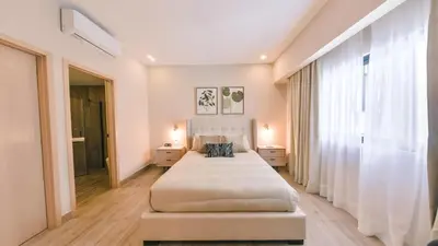 a bedroom with two beds and a large window at Fully Serviced Apartment at Regatta Living II - 304 in Santo Domingo