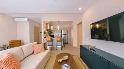 a living room with a white couch and a table at Fully Serviced Apartment at Regatta Living II - 304 in Santo Domingo