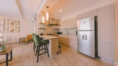 a kitchen with a refrigerator and a table and chairs at Fully Serviced Apartment at Regatta Living II - 905 in Santo Domingo