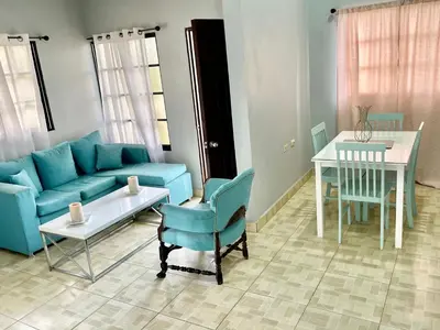 a living room with a blue couch and a table at Oasis de paz 2 in Jarabacoa