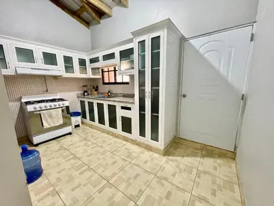 a kitchen with white cabinets and a white door at Oasis de paz 2 in Jarabacoa