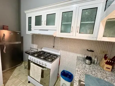 a kitchen with a stove and white cabinets at Oasis de paz 2 in Jarabacoa