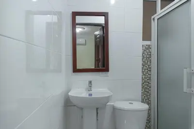 a white bathroom with a sink and a toilet at Tropical Island Aparthotel - Santo Domingo EsteRD in Santo Domingo