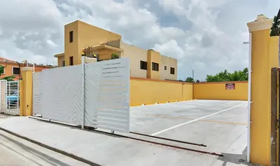 a gate in a parking lot in front of a building at Cozy Guest Room in Santo Domingo Este with Private Entrance in La Viva