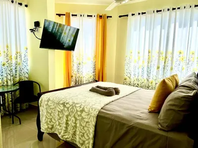 a bedroom with a bed with a flat screen tv at Hotel Maria Bonita Higüey in Higuey