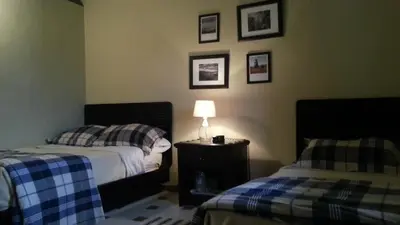 a bedroom with two beds and a lamp on a table at Hotel Altocerro in Constanza