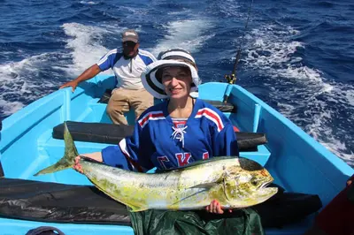 a woman in a boat holding a large fish at Chaykovski Boutique H in Las Terrenas