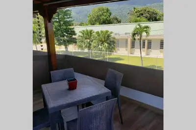 a table and chairs on a balcony with a view of a building at Great location, right downtown Puerto plata . in San Felipe de Puerto Plata