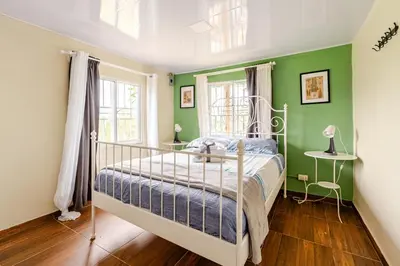 a bedroom with green walls and a bed at Chulavista Constanza casa campito in Arroyo Frío