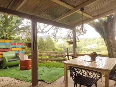 a patio with a table and chairs and a fence at Chulavista Constanza casa campito in Arroyo Frío