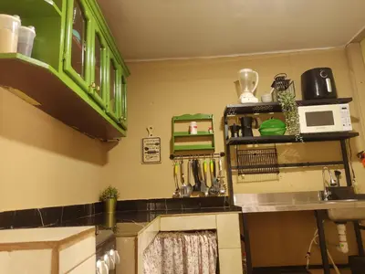 a kitchen with green cabinets and a counter top at Chulavista Constanza casa campito in Arroyo Frío