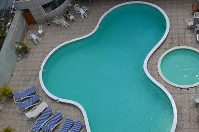 an overhead view of a swimming pool with chaises and chairs at Hotel Renacer in Santo Domingo