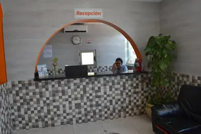 a woman taking a picture of a mirror in a reception room at Hotel Renacer in Santo Domingo