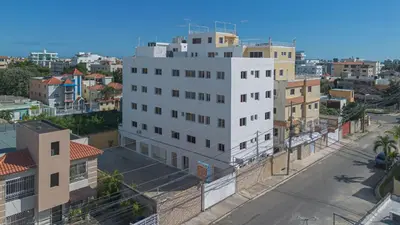 a tall white building in a city with buildings at Double Room, Corales del SurOle Las Americas- Isabelita - Aeropuerto-Aeropuerto in La Viva