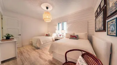 a bedroom with two beds and a table and a window at Special Price Deluxe 2BR at El Portillo in Las Terrenas
