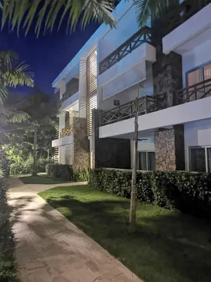 a building with a palm tree in front of it at Samán Residences D3 in Las Terrenas