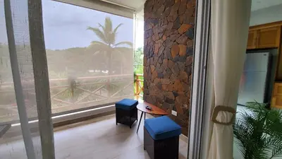 a room with a large window and a table and stools at Samán Residences D3 in Las Terrenas