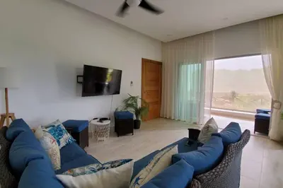 a living room with a blue couch and a tv at Samán Residences D3 in Las Terrenas