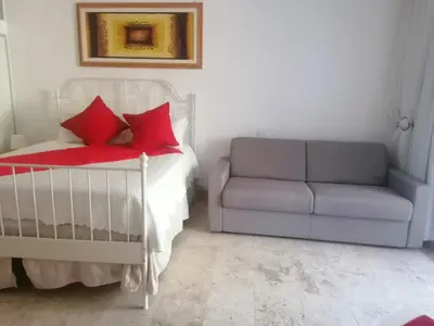 a bedroom with a bed and a couch and a chair at Apartment Monocal in Boca Chica in Boca Chica