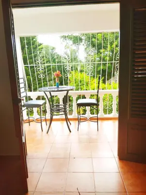 a porch with a table and chairs and a window at Estudio Jardín Escondido in Las Galeras