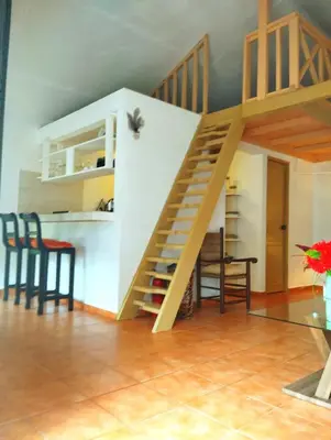 a staircase in a room with chairs and a table at Estudio Jardín Escondido in Las Galeras