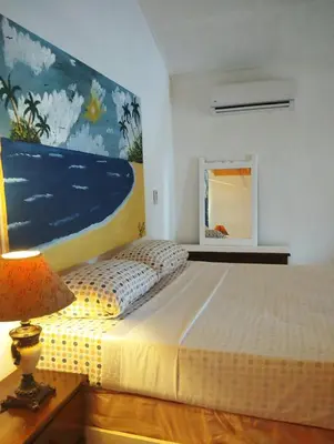 a bedroom with a bed and a painting on the wall at Estudio Jardín Escondido in Las Galeras