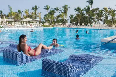 two people in the swimming pool at a resort at Riu Republica - Adults Only - All Inclusive in Punta Cana