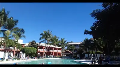 a large swimming pool with palm trees and buildings at Private room in the Boca Chica Resort condominium in Boca Chica