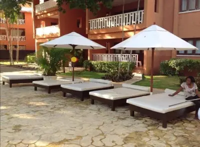 a group of benches with umbrellas in front of a building at Private room in the Boca Chica Resort condominium in Boca Chica