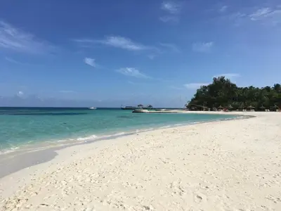 a white beach with blue water and trees in the background at Private room in the Boca Chica Resort condominium in Boca Chica