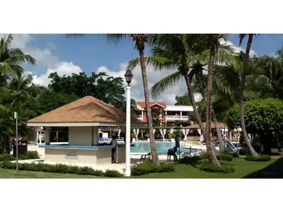 a resort with a swimming pool and palm trees at Private room in the Boca Chica Resort condominium in Boca Chica