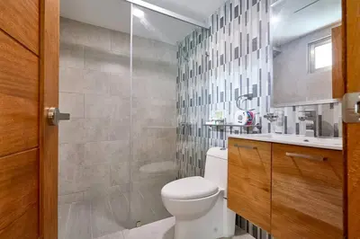 a bathroom with a toilet and a sink at Escape Apartments, Balcony, Pool, Gym & Spa in La Julia in Santo Domingo