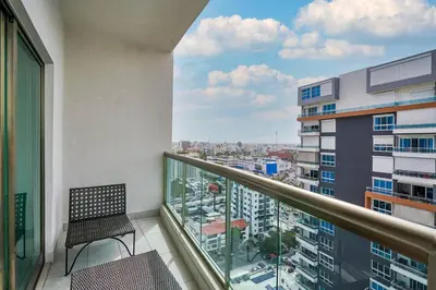 a balcony with a chair and a view of a city at Escape Apartments, Balcony, Pool, Gym & Spa in La Julia in Santo Domingo