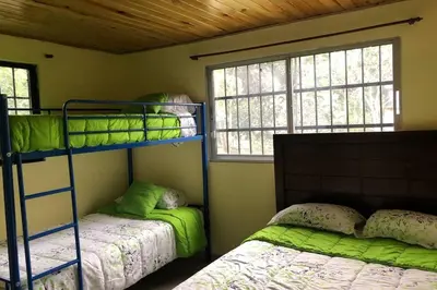 a bedroom with two bunk beds and a window at Acogedora Casa Rural en plena naturaleza frente al Río con piscina Bonao in Bonao