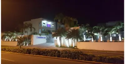 a building with palm trees in front of a street at Furnished Apartment - Residencial Olas - Gated Community - 24 hr Security in San Felipe de Puerto Plata