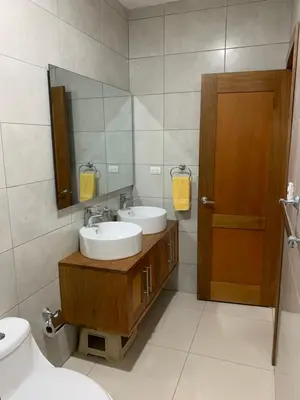 a bathroom with a sink and a mirror and a toilet at Furnished Apartment - Residencial Olas - Gated Community - 24 hr Security in San Felipe de Puerto Plata