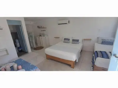 a room with two beds and a couch in it at Apartamento Los Blancos, a dos Minutos de los Patos Barahona in Enriquillo